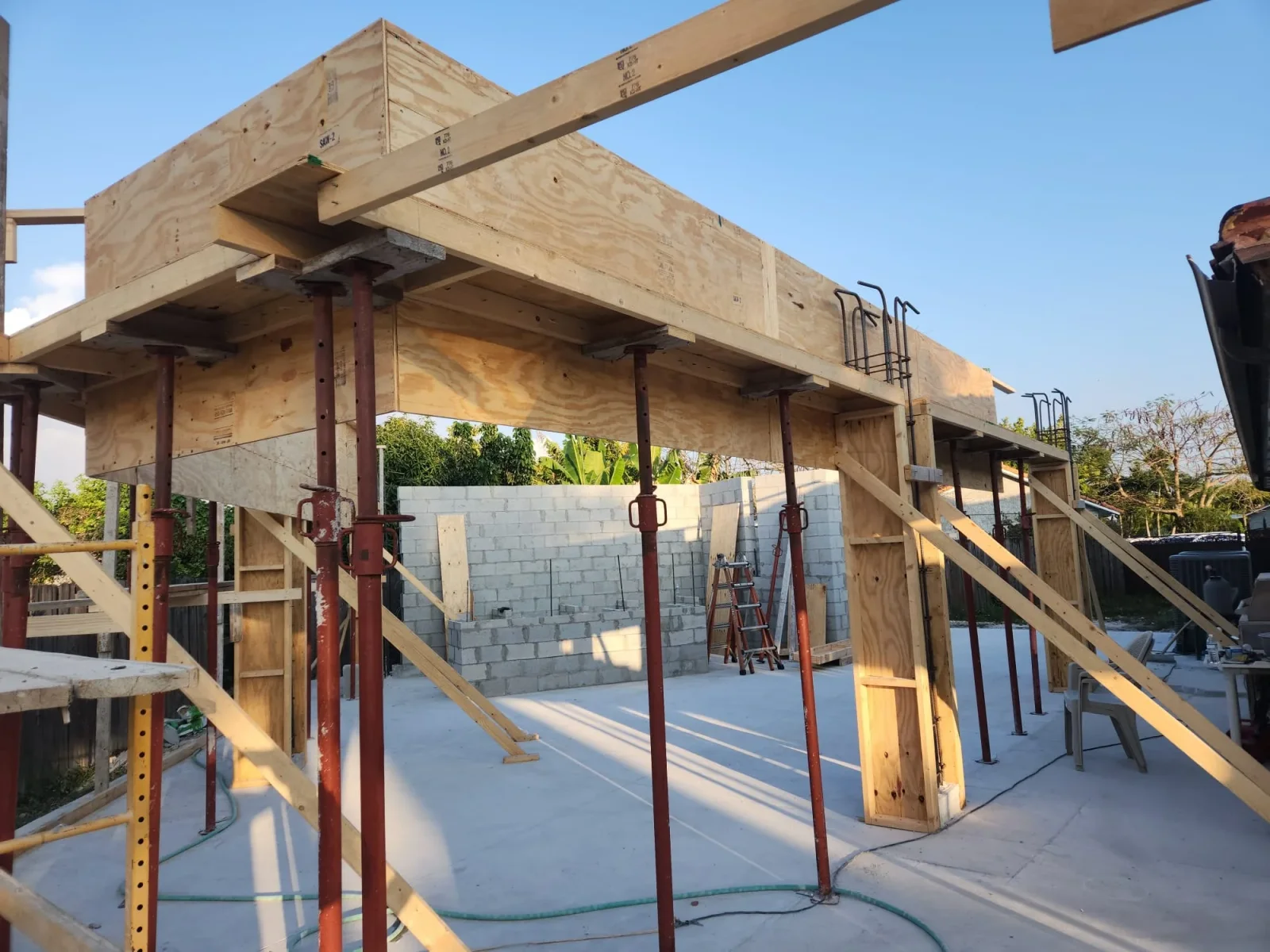 Wood-framed commercial building with steel columns, concrete foundation, and CMU walls under construction