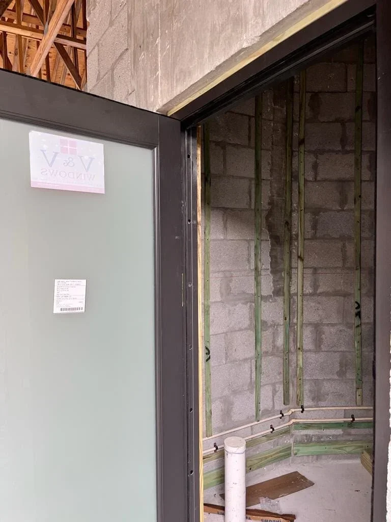 Metal stud framing and drywall installation on concrete block wall interior