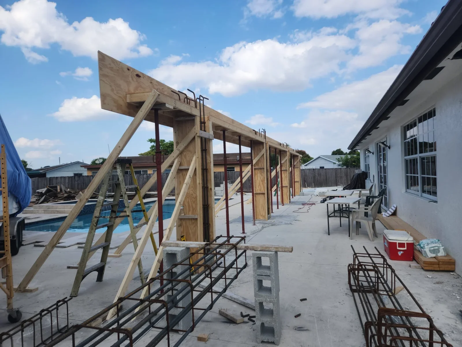 Timber frame construction with steel bracing, concrete foundation blocks, and concrete slab flooring